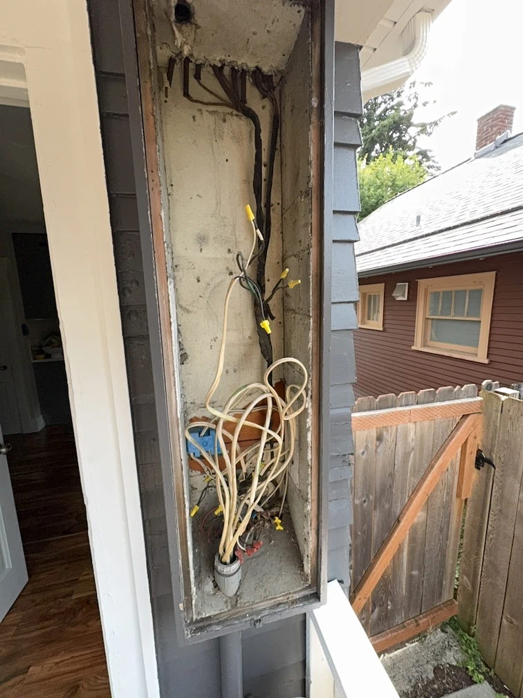 Old electrical panel with exposed wiring before replacement