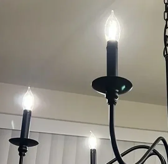 Close-up of candle-style bulbs on a newly installed chandelier