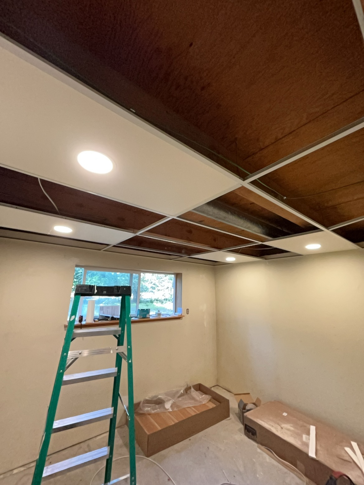 Basement recessed can lights being installed by Washington Electrical