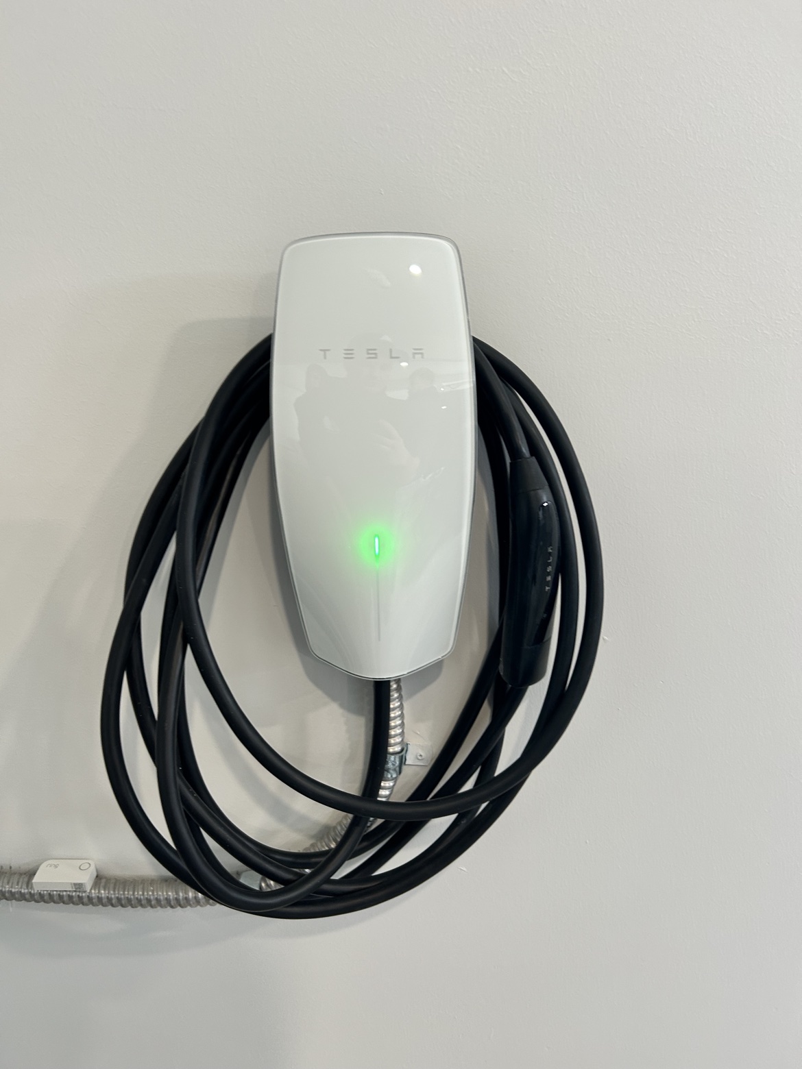 Tesla Wall Connector installed on a white wall by Washington Electrical