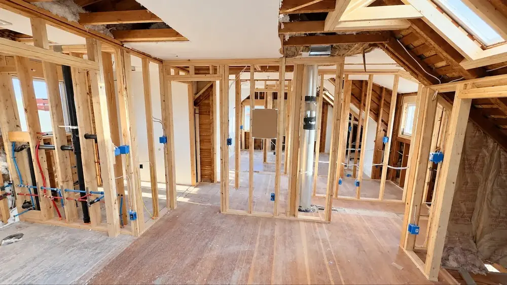 Same room after rewiring, with new cable and blue electrical boxes in the open walls